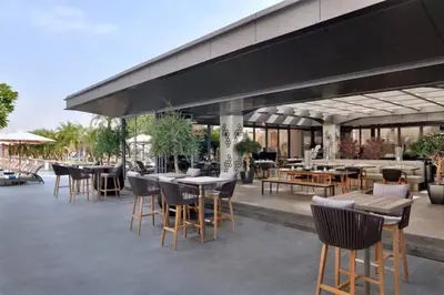 an outdoor patio with tables and chairs and a building at Vogue Downtown Emaar Residence Fashion Avenue with Direct Access to Dubai Mall, Studio Apartment with Balcony Overlooking Burj Khalifa View, Access to all Amenitties in Dubai