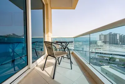 a balcony with a table and chairs on it at Lake-View Apartment Near City Centre Meaisem Mall, Just Minutes from Dubai Autodrome and ICC Cricket Stadium - The Crescent A, Dubai Production City by Deluxe Holiday Homes in Dubai