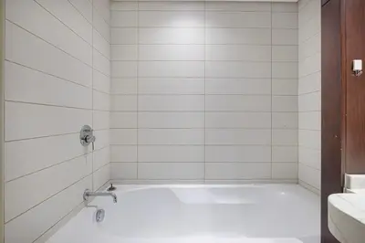 a white bathroom with a tub and a sink at Luxury 2BR in Downtown w Iconic Burj Khalifa View Burj Views 303 in Dubai