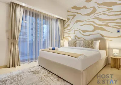 a bedroom with a bed and a tree mural at Spacious 1BR Apartment - The Jewels Tower 2 - Dubai Marina in Dubai