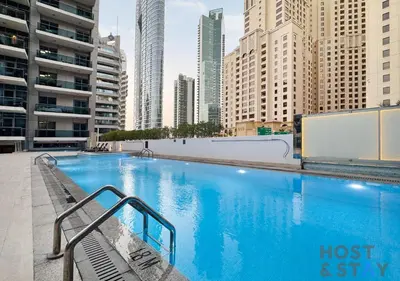 a large swimming pool in a city with tall buildings at Spacious 1BR Apartment - The Jewels Tower 2 - Dubai Marina in Dubai