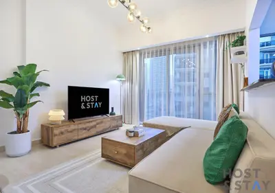 a living room with a couch and a tv at Spacious 1BR Apartment - The Jewels Tower 2 - Dubai Marina in Dubai