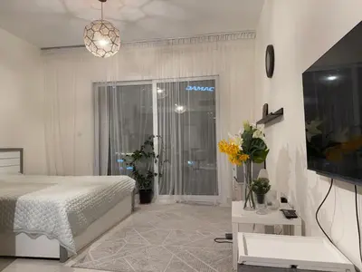 a bedroom with a bed and a window and a tv at Convenient studio in the centre of Dubai in Dubai