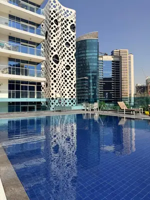 a swimming pool in front of a building with buildings at Convenient studio in the centre of Dubai in Dubai