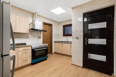 a kitchen with a stove and a black door at Luxury 4 BHK Villa in JVC by dPie in Dubai