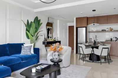a living room with a blue couch and a kitchen at Ultra Luxury Emaar Palace Beachfront 1BR Five Palm in Dubai