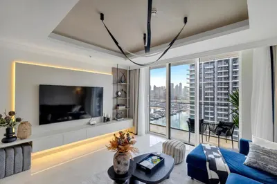 a living room with a tv and a large window at Ultra Luxury Emaar Palace Beachfront 1BR Five Palm in Dubai