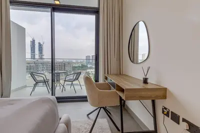 a hotel room with a desk and a mirror at Oxford Terraces, JVC - Studio Apartment - Allsopp & Allsopp in Dubai