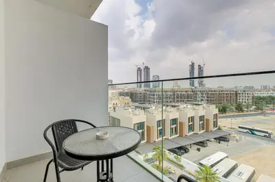 a balcony with a table and a view of a city at Oxford Terraces, JVC - Studio Apartment - Allsopp & Allsopp in Dubai