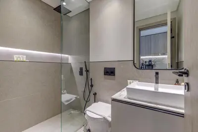 a bathroom with a sink and a mirror and a toilet at Oxford Terraces, JVC - Studio Apartment - Allsopp & Allsopp in Dubai