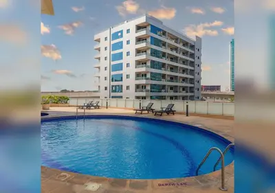 a large building with a swimming pool in front of a building at Premium Ensuite Room With Balcony in Dubai