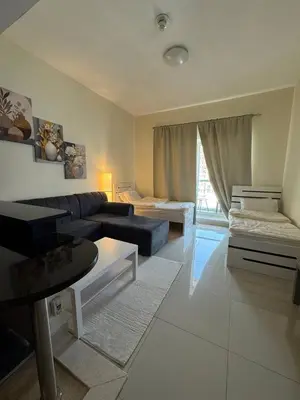 a living room with a couch and a living room at Modern Studio Apartment in Dubai Sports City in Dubai