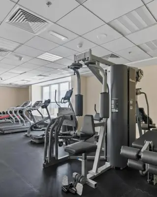 a gym with rows of treadmills and ellipticals at Modern Studio Apartment in Dubai Sports City in Dubai