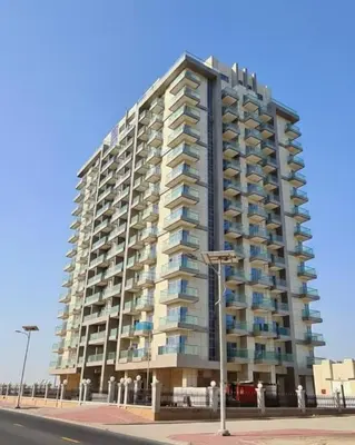 a tall building on the side of a street at Modern Studio Apartment in Dubai Sports City in Dubai