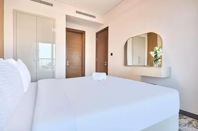 a bedroom with a white bed and a mirror at STAY BY LATINEM Luxury 1BR Holiday Home CA 0305 Near Burj Khalifa in Dubai