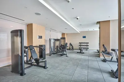 a gym with treadmills and chairs in a room at STAY BY LATINEM Luxury 1BR Holiday Home CA 0305 Near Burj Khalifa in Dubai