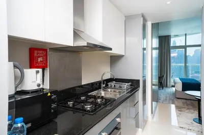 a kitchen with a sink and a stove top oven at Canal Bliss Studio- DAMAC Maison Prive in Dubai