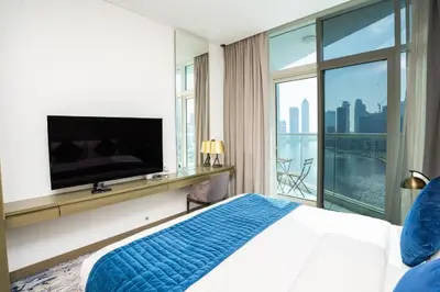 a bedroom with a large bed and a flat screen tv at Canal Bliss Studio- DAMAC Maison Prive in Dubai