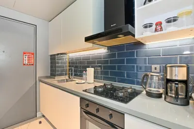 a kitchen with blue tiles on the wall at Downtown Dubai, Canal view ,Mag318 in Dubai