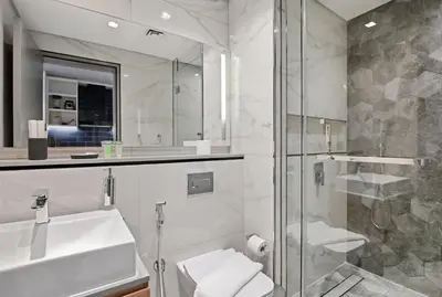 a bathroom with a sink and a glass shower at Downtown Dubai, Canal view ,Mag318 in Dubai