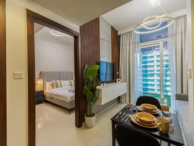 a hotel room with a dining table and a bedroom at Centrally Located 1 BR in Damac Reva - 7 Min walk to Dubai Mall in Dubai