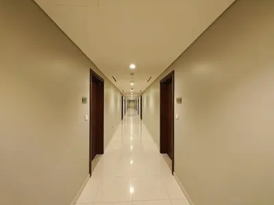 a corridor of a building with white walls and a long hallway at Centrally Located 1 BR in Damac Reva - 7 Min walk to Dubai Mall in Dubai