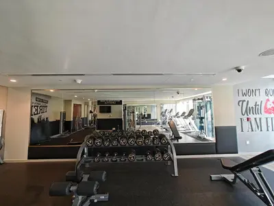 a gym with rows of exercise equipment and a mirror at Centrally Located 1 BR in Damac Reva - 7 Min walk to Dubai Mall in Dubai