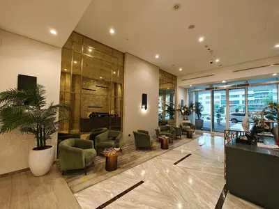 a lobby with a waiting area with chairs and a piano at Centrally Located 1 BR in Damac Reva - 7 Min walk to Dubai Mall in Dubai
