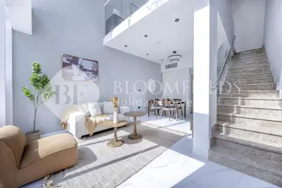 a living room with blue walls and a staircase at Bloomfields Deluxe 1br Rukan in Dubai