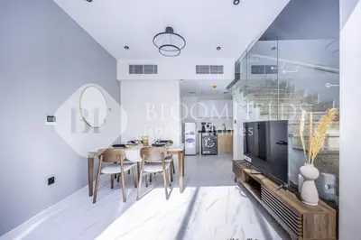 a dining room with a table and a tv at Bloomfields Deluxe 1br Rukan in Dubai