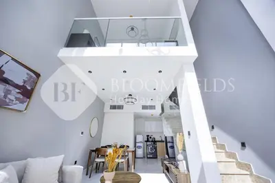 a staircase in a living room with white walls at Bloomfields Deluxe 1br Rukan in Dubai