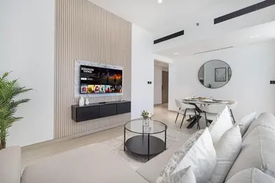 a living room with a couch and a table at 1BR Luxury Stay With Pool, Gym and Skyline View in Dubai