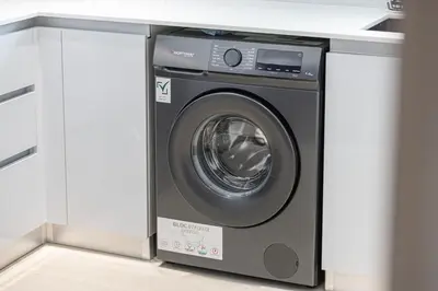 a washing machine in a room with a counter at 1BR Luxury Stay With Pool, Gym and Skyline View in Dubai