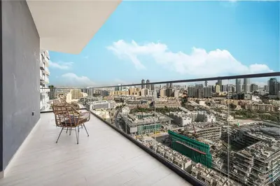 a balcony with two chairs and a view of a city at 1BR Luxury Stay With Pool, Gym and Skyline View in Dubai