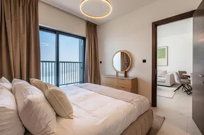 a bedroom with a large bed and a large window at Elegant 2-Bedroom Apartment with Stunning City and Water Views in Dubai