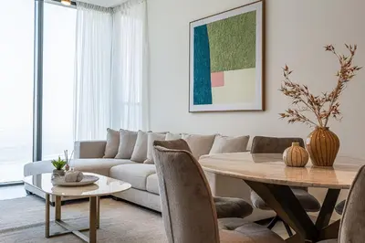 a living room with a couch and a table at Elegant 2-Bedroom Apartment with Stunning City and Water Views in Dubai