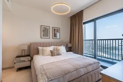 a bedroom with a bed and a large window at Elegant 2-Bedroom Apartment with Stunning City and Water Views in Dubai