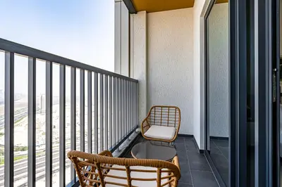 a balcony with two chairs and a chair at Elegant 2-Bedroom Apartment with Stunning City and Water Views in Dubai