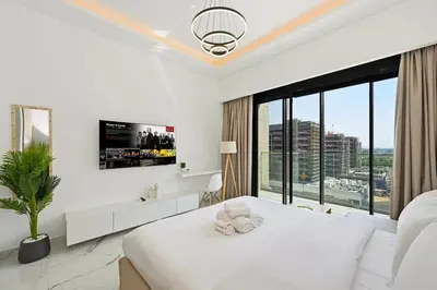 a white bedroom with a white bed and a large window at Estudio Noor en Dubai Por beBalmy in Dubai