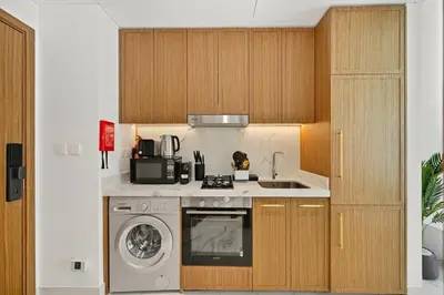 a kitchen with a sink and a washing machine at Estudio Noor en Dubai Por beBalmy in Dubai