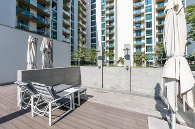a patio with two chairs and a table and umbrellas at Stunning I Biggest Studio I Near To Downtown in Dubai