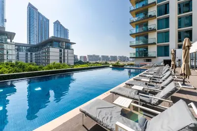 a swimming pool with lounge chairs and a building at Stunning I Biggest Studio I Near To Downtown in Dubai