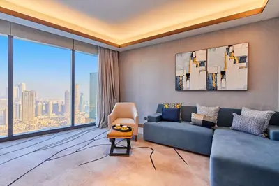 a living room with a blue couch and a large window at Premium 5 bedroom penthouse opposite Burj Khalifa in Dubai