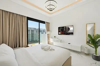 a white bedroom with a large bed and a large window at Estudio Sultan en Dubái por beBalmy in Dubai