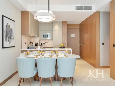 a kitchen with a table with white chairs at keylid-2BR-Address Opera-5 mins walk to Dubai Mall in Dubai