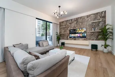 a living room with a couch and a tv at Dubai Hills Townhouse in Dubai