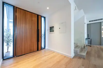 an empty room with a wooden door and a staircase at Dubai Hills Townhouse in Dubai