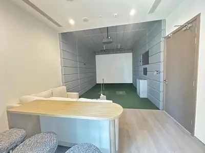 a room with a table and chairs and a screen at Royal suite at Liv marina views in Dubai