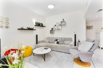 a living room with a couch and a table at 2-Bedroom Haven with Canal View near The Els Club in Dubai