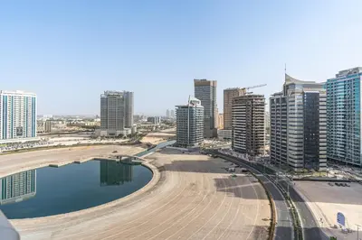 a city with tall buildings and a body of water at 2-Bedroom Haven with Canal View near The Els Club in Dubai